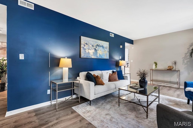5858 Nina Pl # 1W, Saint Louis, MO 63112 - living area with an accent wall and wood finished floors