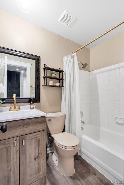 5858 Nina Pl # 1W, Saint Louis, MO 63112 - bathroom featuring shower / bath combo, vanity, and wood finished floors