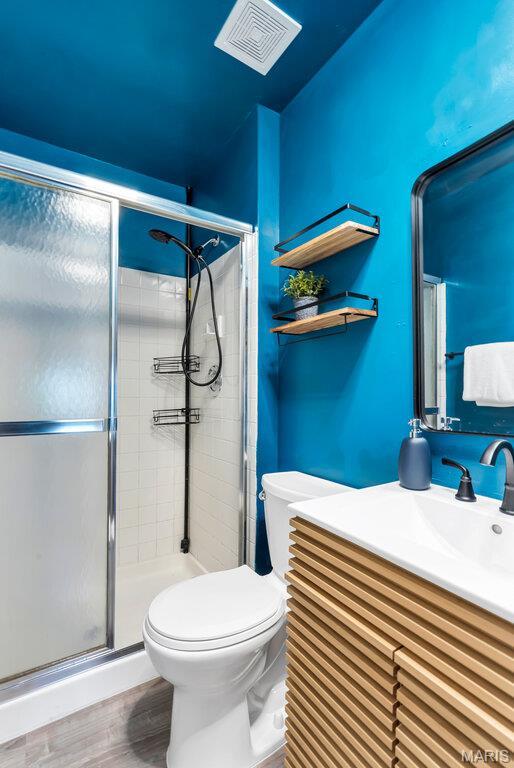 5858 Nina Pl # 1W, Saint Louis, MO 63112 - full bath with vanity, a stall shower, and wood finished floors