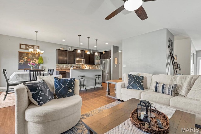 144 Wilmer Valley Dr, Wentzville, MO 63385 - living room featuring a ceiling fan, light wood-style flooring, recessed lighting, and a chandelier