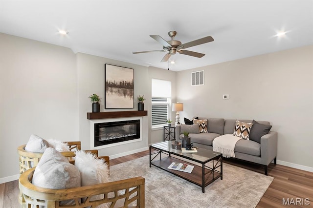 341 Newbridge Way, Ofallon, MO 63368 - living room with ceiling fan, a glass covered fireplace, and wood finished floors