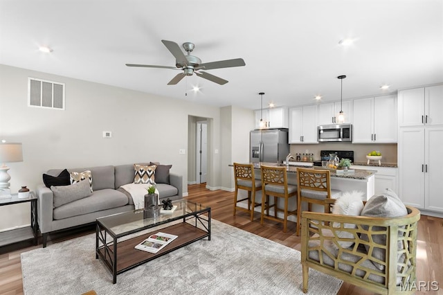 341 Newbridge Way, Ofallon, MO 63368 - living area with a ceiling fan, light wood finished floors, and recessed lighting