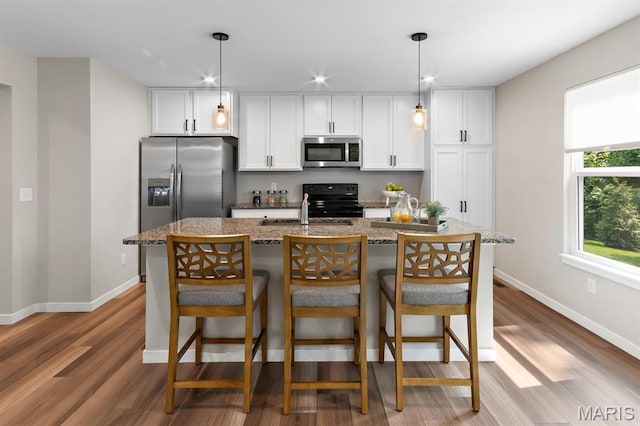 341 Newbridge Way, Ofallon, MO 63368 - kitchen with stainless steel appliances, white cabinetry, wood finished floors, a breakfast bar, and recessed lighting