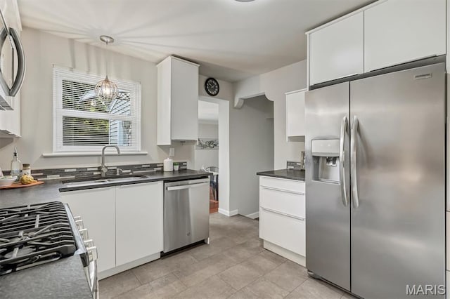 657 Lilac Ave, Webster Groves, MO 63119 - kitchen with appliances with stainless steel finishes, white cabinetry, dark countertops, and light tile patterned floors