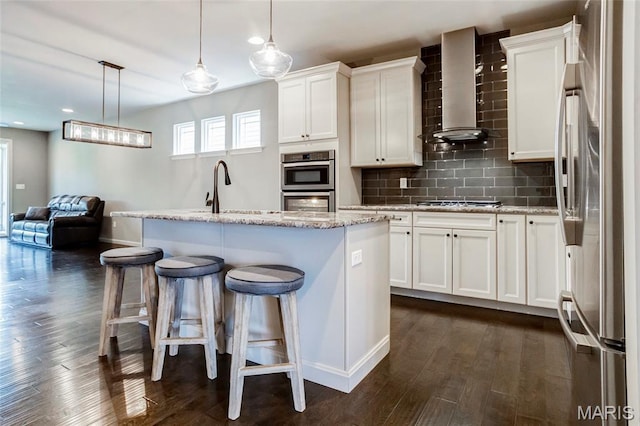 2216 Cournier St, Saint Charles, MO 63301 - kitchen with wall chimney range hood, appliances with stainless steel finishes, white cabinetry, dark wood-type flooring, and recessed lighting