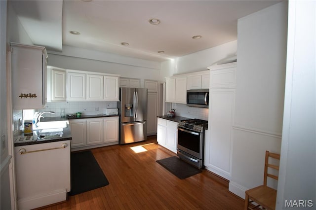 37 Joy Ave, Webster Groves, MO 63119 - kitchen featuring stainless steel appliances, dark countertops, decorative backsplash, dark wood-style flooring, and recessed lighting