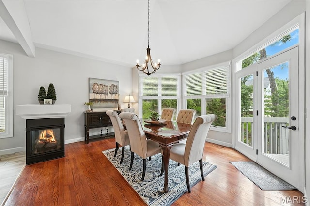 17 Eagles Way Ln, Lake St Louis, MO 63367 - dining room featuring a chandelier, a glass covered fireplace, and wood finished floors