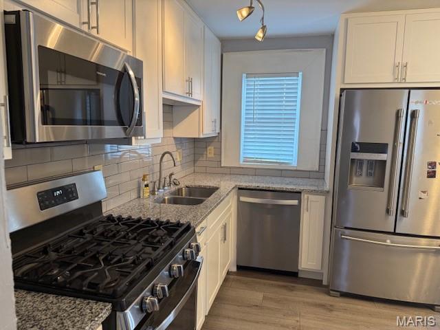 1496 Ville Rosa Ln, Hazelwood, MO 63042 - kitchen with appliances with stainless steel finishes, white cabinetry, and light stone counters