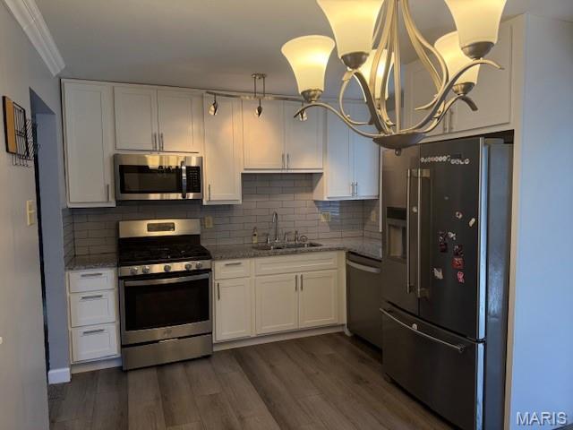 1496 Ville Rosa Ln, Hazelwood, MO 63042 - kitchen featuring stainless steel appliances, white cabinets, a chandelier, light stone counters, and ornamental molding