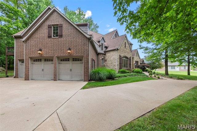 3046 Beaver Creek Cpe, Girardeau, MO 63701 - view of front facade with driveway, brick siding, a garage, and a front lawn