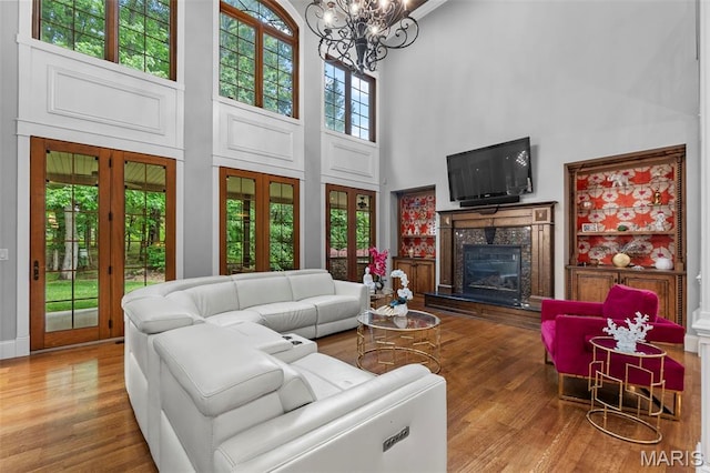 3046 Beaver Creek Cpe, Girardeau, MO 63701 - living area with a towering ceiling, a fireplace, wood finished floors, and a chandelier