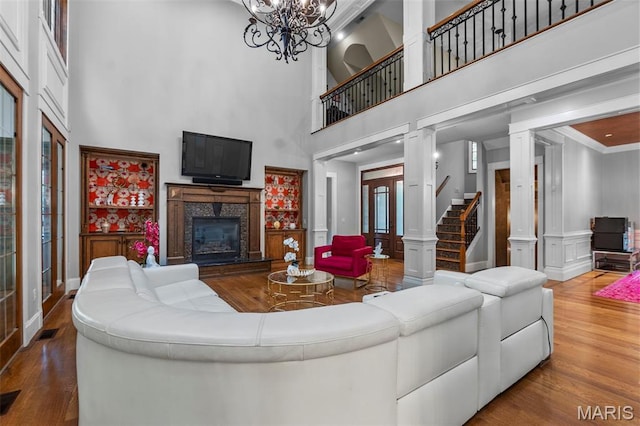 3046 Beaver Creek Cpe, Girardeau, MO 63701 - living area featuring wood finished floors, a premium fireplace, a towering ceiling, a chandelier, and stairway