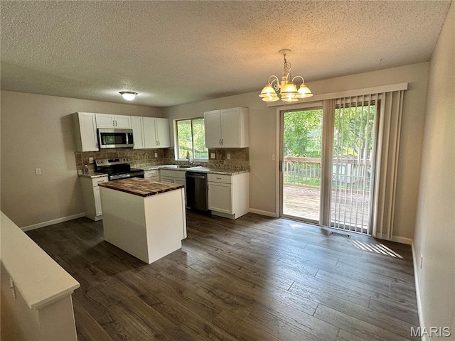 807 Corey Ct, Wentzville, MO 63385 - kitchen with stainless steel appliances, a sink, a textured ceiling, a chandelier, and white cabinetry