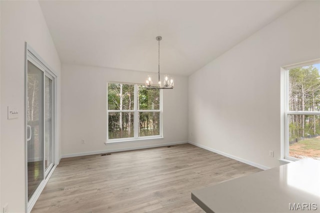 1720 Martingale Ln, Eureka, MO 63025 - unfurnished dining area with lofted ceiling, a chandelier, light wood-type flooring, and baseboards