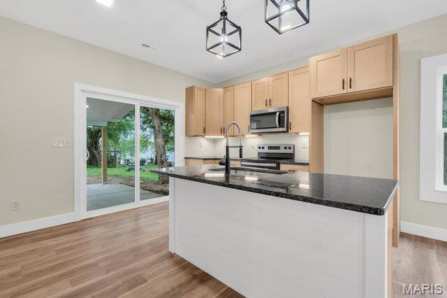 410 Roosevelt, Warrenton, MO 63383 - kitchen with stainless steel appliances, light wood-style floors, light brown cabinetry, and decorative light fixtures