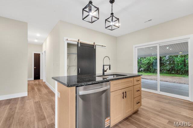 410 Roosevelt, Warrenton, MO 63383 - kitchen featuring stainless steel dishwasher, light wood finished floors, a barn door, dark stone counters, and decorative light fixtures
