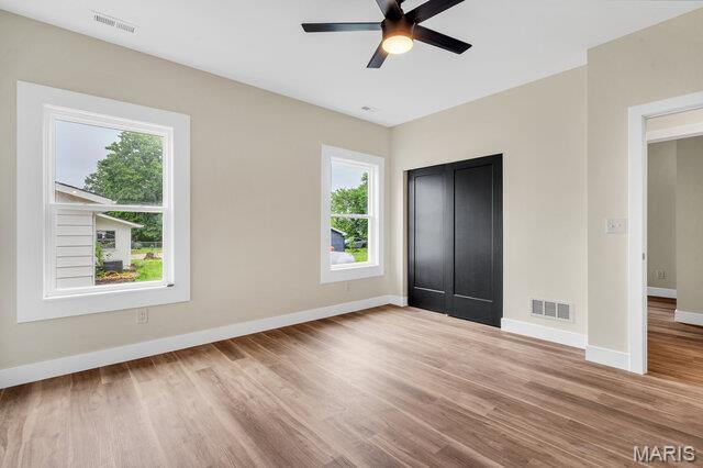 410 Roosevelt, Warrenton, MO 63383 - unfurnished bedroom featuring multiple windows, wood finished floors, and ceiling fan