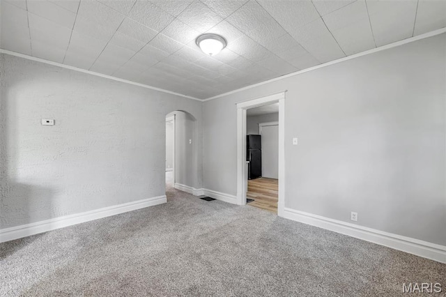 1323 Fairview Ave, University City, MO 63130 - spare room featuring ornamental molding, arched walkways, carpet flooring, and baseboards
