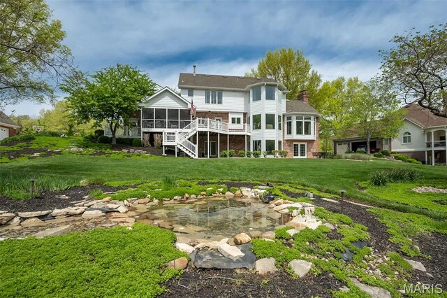 1417 Wheatfield Ln, Saint Albans, MO 63073 - rear view of house featuring a sunroom, a chimney, brick siding, stairs, and a lawn