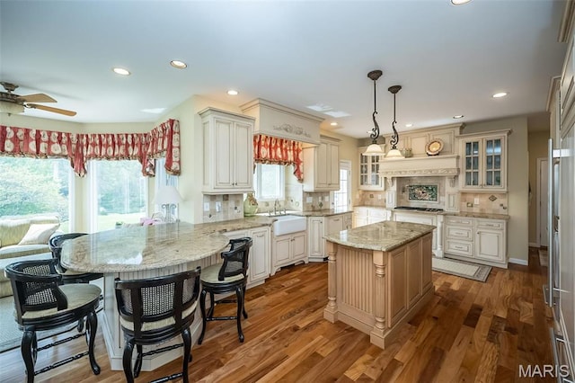 1417 Wheatfield Ln, Saint Albans, MO 63073 - kitchen with a peninsula, gas stovetop, recessed lighting, glass insert cabinets, and ceiling fan