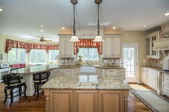 1417 Wheatfield Ln, Saint Albans, MO 63073 - kitchen featuring backsplash, a kitchen island, glass insert cabinets, recessed lighting, and light stone countertops