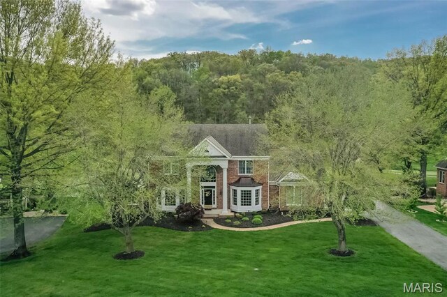 1417 Wheatfield Ln, Saint Albans, MO 63073 - neoclassical / greek revival house featuring a front yard and a forest view
