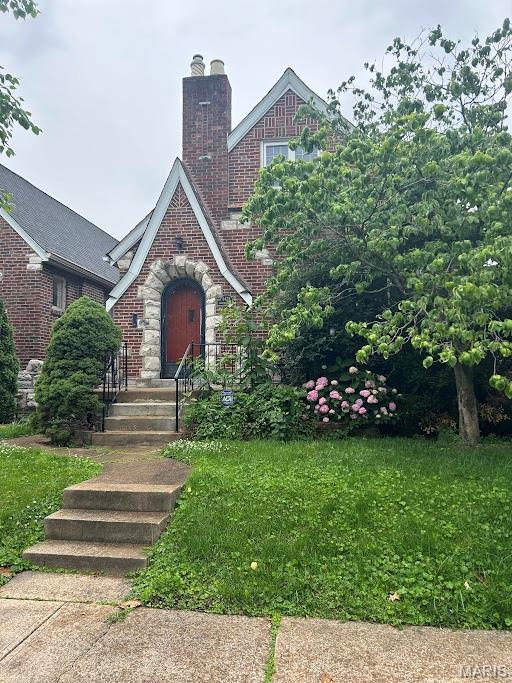 5424 Gresham Ave, Saint Louis, MO 63109 - tudor house featuring a chimney, brick siding, and a front lawn