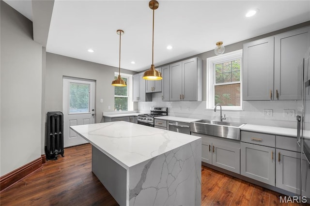 2910 Allen Ave, Saint Louis, MO 63104 - kitchen featuring appliances with stainless steel finishes, gray cabinets, a center island, radiator heating unit, and decorative backsplash