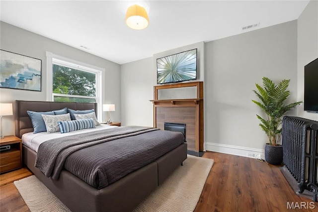 2910 Allen Ave, Saint Louis, MO 63104 - bedroom with wood finished floors, a fireplace, and radiator heating unit