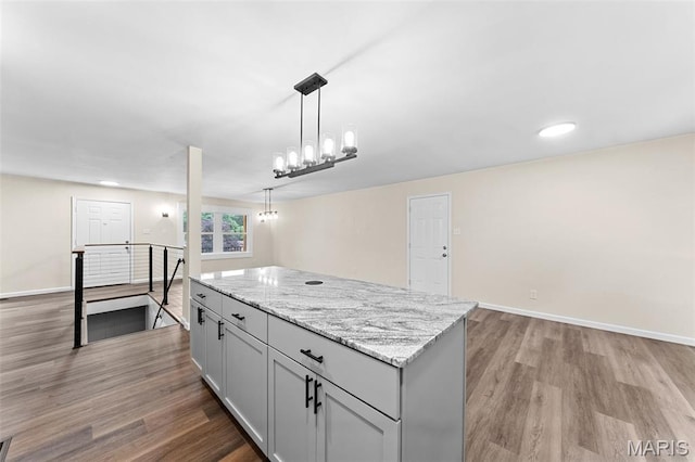 2019 San Pedro Dr, Arnold, MO 63010 - kitchen featuring light wood-type flooring, a kitchen island, decorative light fixtures, light stone counters, and recessed lighting
