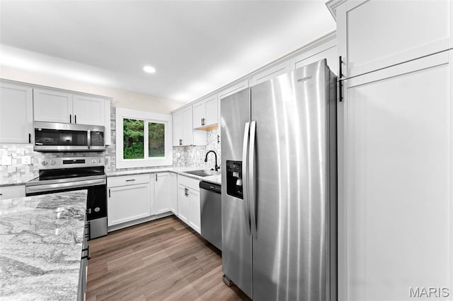 2019 San Pedro Dr, Arnold, MO 63010 - kitchen featuring stainless steel appliances, backsplash, light stone countertops, dark wood finished floors, and recessed lighting