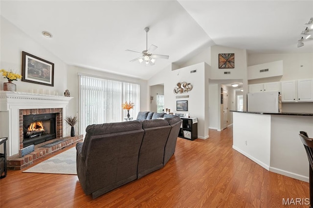1275 Gardens Circle Drive E, Saint Louis, MO 63125 - living area with a brick fireplace, vaulted ceiling, ceiling fan, and light wood-type flooring