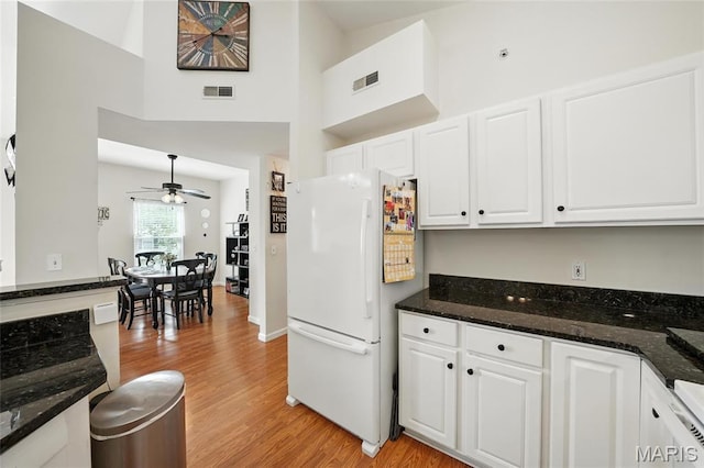 1275 Gardens Circle Drive E, Saint Louis, MO 63125 - kitchen with freestanding refrigerator, light wood finished floors, ceiling fan, white cabinets, and a towering ceiling