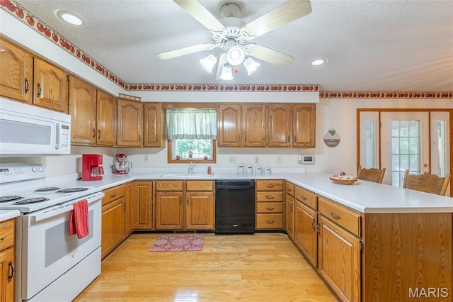 39 Rock Ridge Rd, Wappapello, MO 63966 - kitchen with white appliances, a peninsula, brown cabinetry, a textured ceiling, and recessed lighting