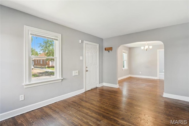6838 Raymond Ave, Saint Louis, MO 63130 - foyer entrance featuring arched walkways, healthy amount of natural light, wood finished floors, and a chandelier