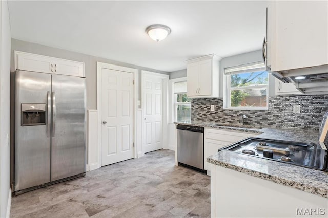 6838 Raymond Ave, Saint Louis, MO 63130 - kitchen with appliances with stainless steel finishes, white cabinetry, tasteful backsplash, light stone countertops, and light wood-style floors