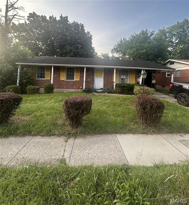 7250 Howdershell Rd, Hazelwood, MO 63042 - ranch-style home with brick siding, a front yard, a carport, and concrete driveway