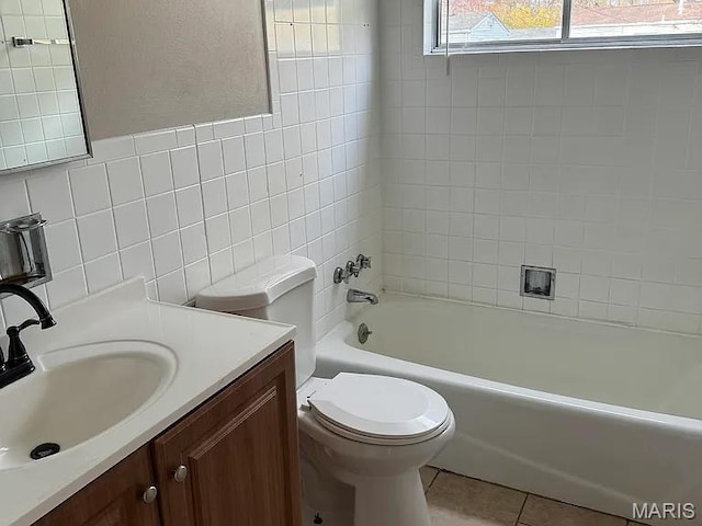 1217 Scott Ave, Saint Ferdinand Township, MO 63138 - bathroom featuring vanity, tile walls, washtub / shower combination, and tile patterned flooring