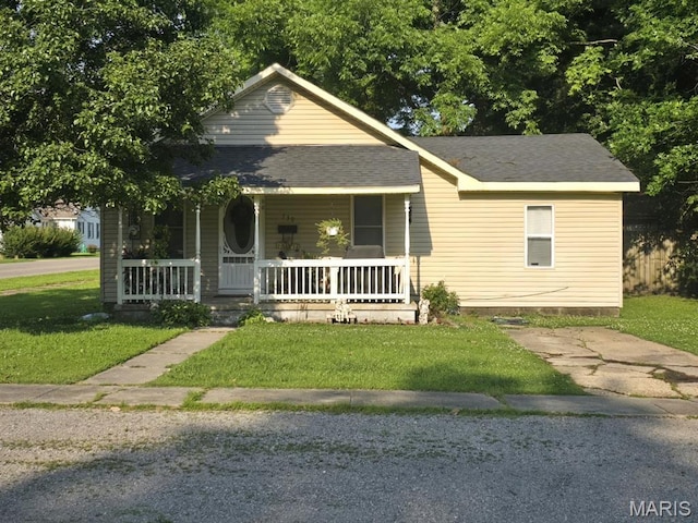 730 N Walnut St, Dexter, MO 63841 - view of front facade featuring a porch, a front lawn, and roof with shingles