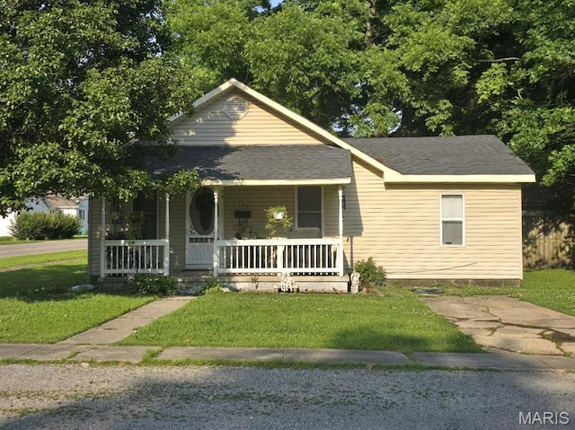 730 N Walnut St, Dexter, MO 63841 - view of front of home with a porch, a front lawn, and roof with shingles
