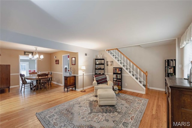 923 N Geyer Rd, Kirkwood, MO 63122 - living room with stairway, plenty of natural light, light wood finished floors, and a chandelier