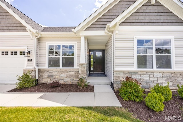 125 Chickasaw Ln, Ofallon, IL 62269 - view of exterior entry featuring stone siding, a garage, and roof with shingles