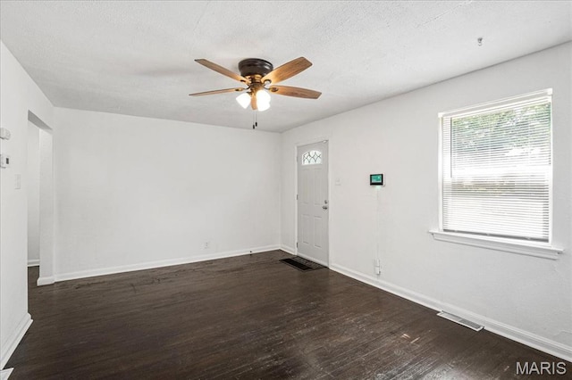 8505 Church Bell Ln, Jennings, MO 63136 - unfurnished room featuring ceiling fan, dark wood-style flooring, and a textured ceiling