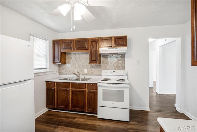 8505 Church Bell Ln, Jennings, MO 63136 - kitchen featuring white appliances, under cabinet range hood, tasteful backsplash, dark wood-style floors, and a textured ceiling
