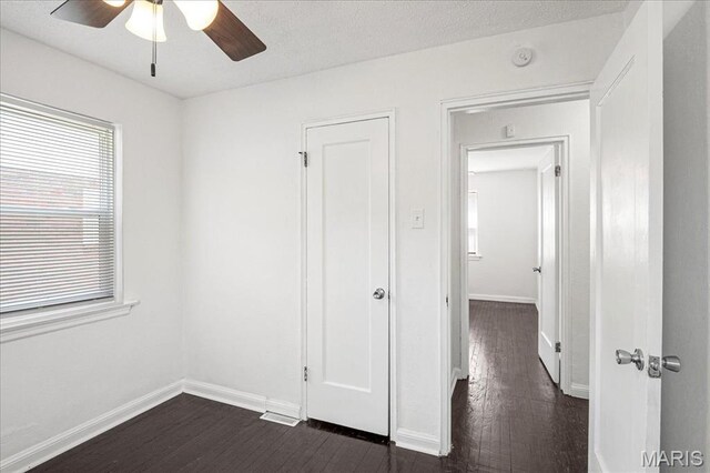 8505 Church Bell Ln, Jennings, MO 63136 - unfurnished bedroom with dark wood-style flooring and a ceiling fan