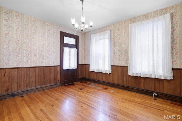503 E State St, Union, MO 63084 - empty room featuring wainscoting, a chandelier, hardwood / wood-style flooring, wood walls, and wallpapered walls