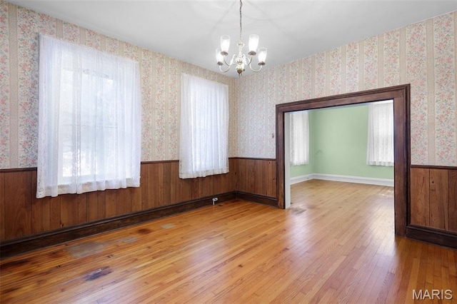 503 E State St, Union, MO 63084 - spare room featuring a chandelier, wood finished floors, wallpapered walls, and a wainscoted wall