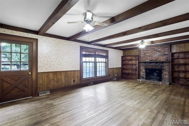 503 E State St, Union, MO 63084 - unfurnished living room featuring a ceiling fan, wainscoting, hardwood / wood-style floors, a fireplace, and beam ceiling