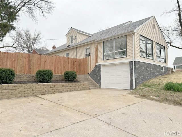 1001 Pike St, Saint Charles, MO 63301 - view of side of property featuring an attached garage, concrete driveway, and a shingled roof