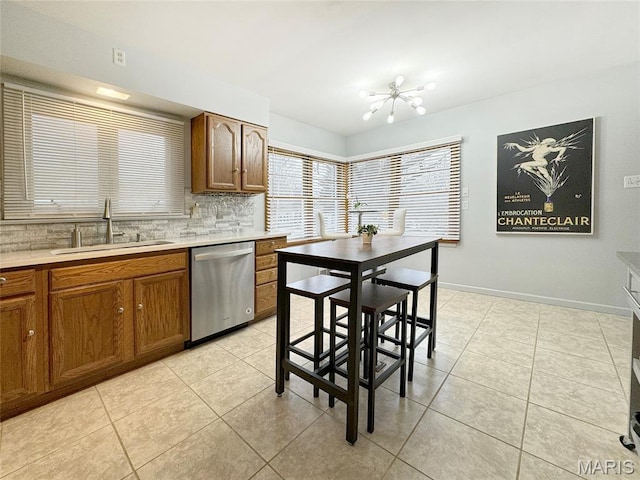 1001 Pike St, Saint Charles, MO 63301 - kitchen featuring stainless steel dishwasher, a chandelier, brown cabinets, light tile patterned flooring, and light countertops